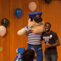 Image of male student taking picture with Louis the Laker, GVSU Mascot
